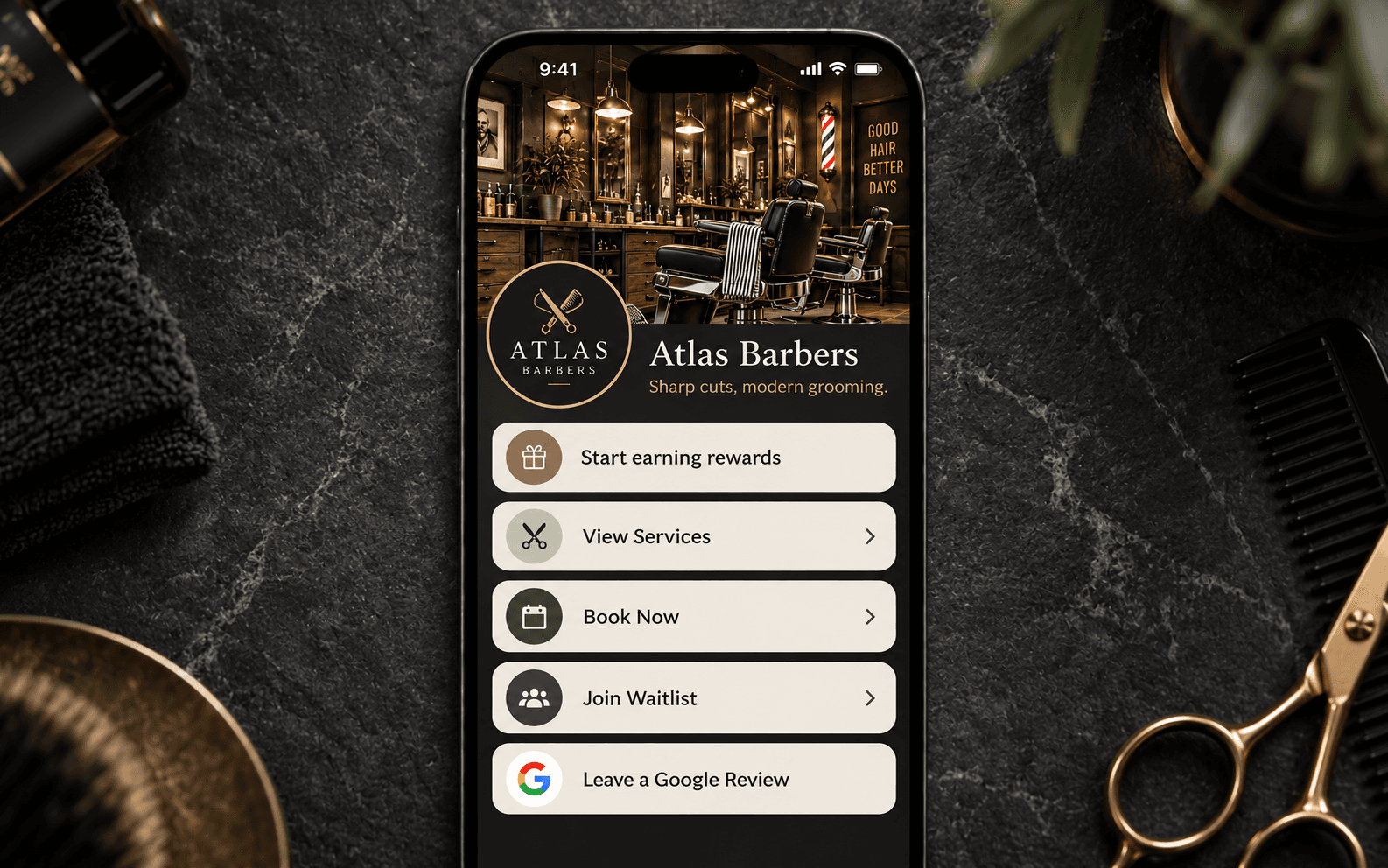 Atlas Barbers app shown on iPhone with grooming tools flat-lay