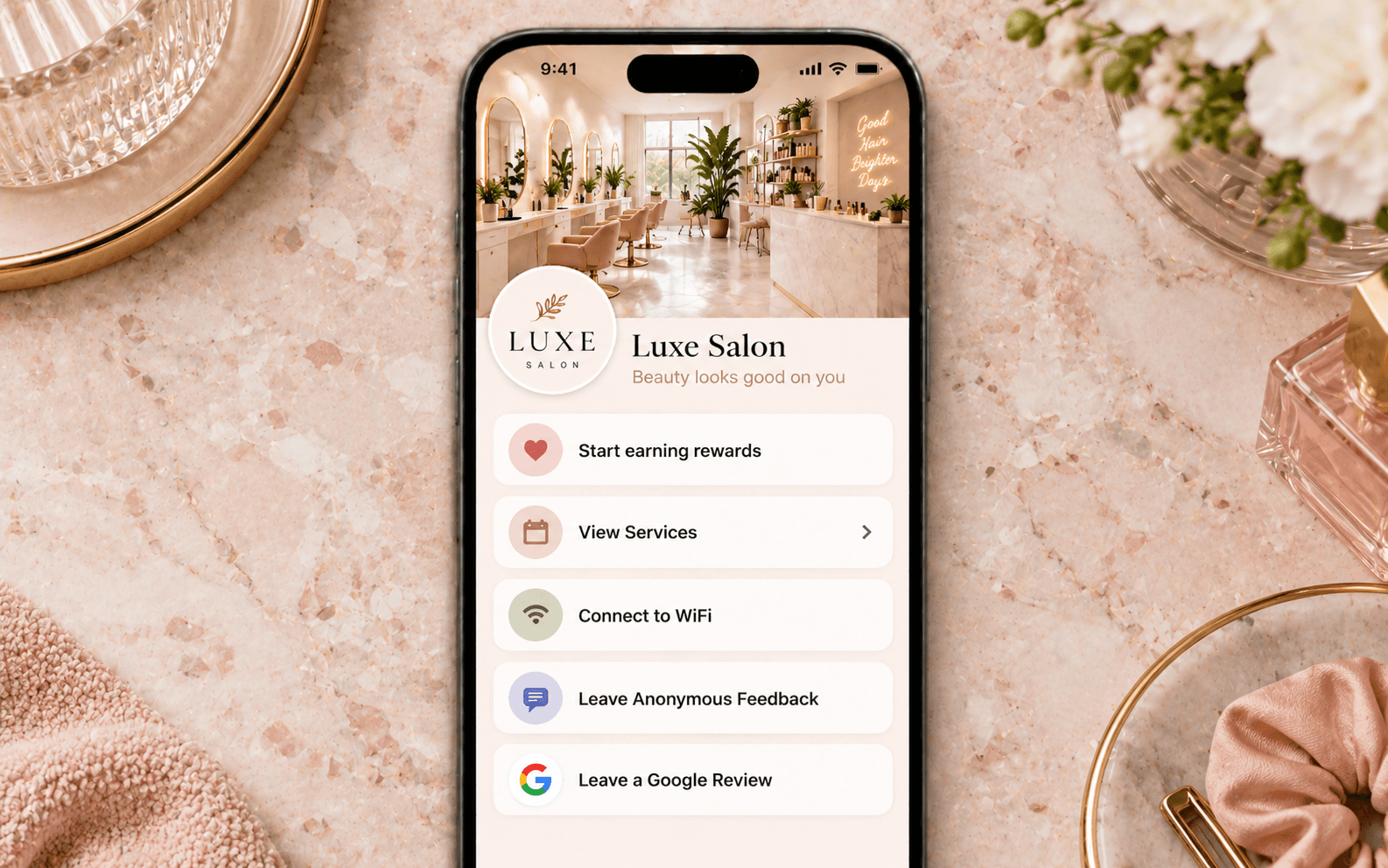 Luxe Salon app shown on iPhone with pink marble flat-lay